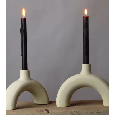 Bougeoir arc en céramique brute avec chandelles noires, style minimaliste.