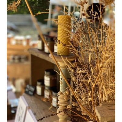 Bougie en cire d'abeille allumée dans un décor chaleureux et authentique.