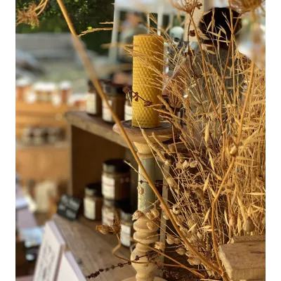 Bougie en cire d'abeille allumée dans un décor chaleureux et authentique.