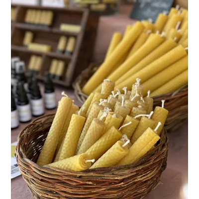 Bougies en cire d'abeille disposées dans un panier pour une ambiance rustique.