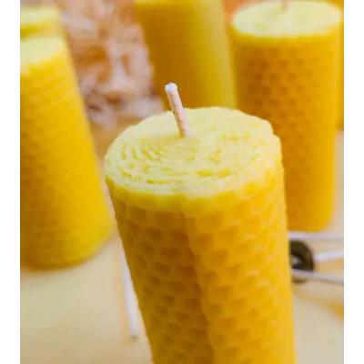 Bougie en cire d'abeille naturelle, montrant sa texture alvéolée et sa mèche artisanale.