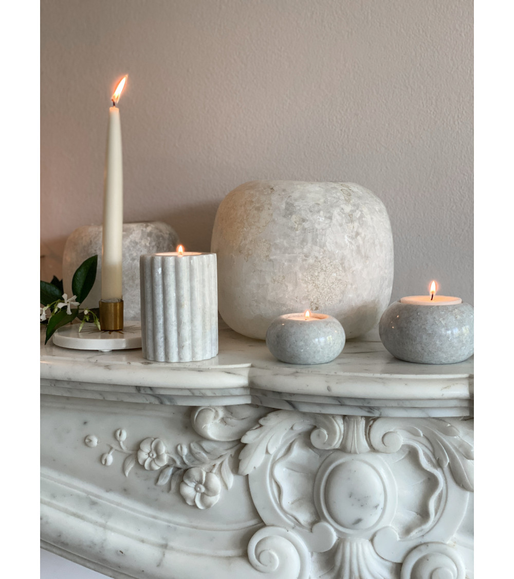 Bougeoir Daisy accompagné de petites bougies en marbre : contraste harmonieux de textures et de formes.