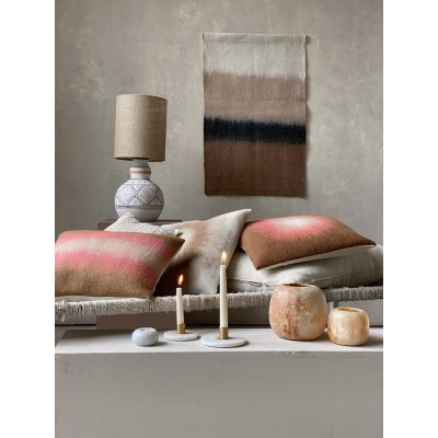 Ambiance salon avec coussins et bougeoirs en marbre, pour un style élégant et accueillant.