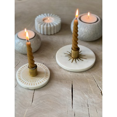 Ambiance chaleureuse avec le bougeoir en marbre L, intégré dans une composition décorative avec d’autres objets en pierre.
