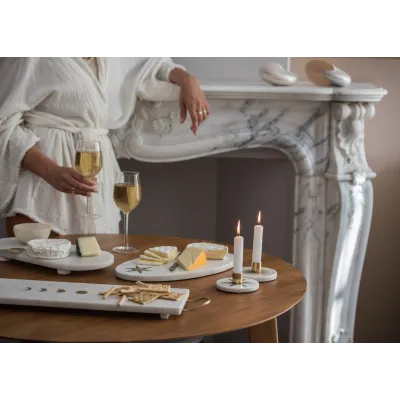 Ambiance cosy avec bougeoirs en marbre sur une table de dégustation.