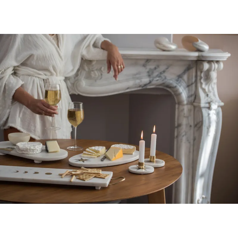 Ambiance cosy avec bougeoirs en marbre sur une table de dégustation.