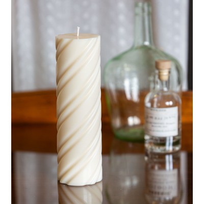 Bougie naturelle et artisanale en cire de colza Ø 7 cm H 23 cm sur une table en verre