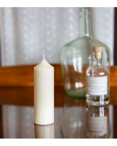 Bougie artisanale en cire naturelle de colza Ø 5 cm H 14 cm posée sur une table en verre