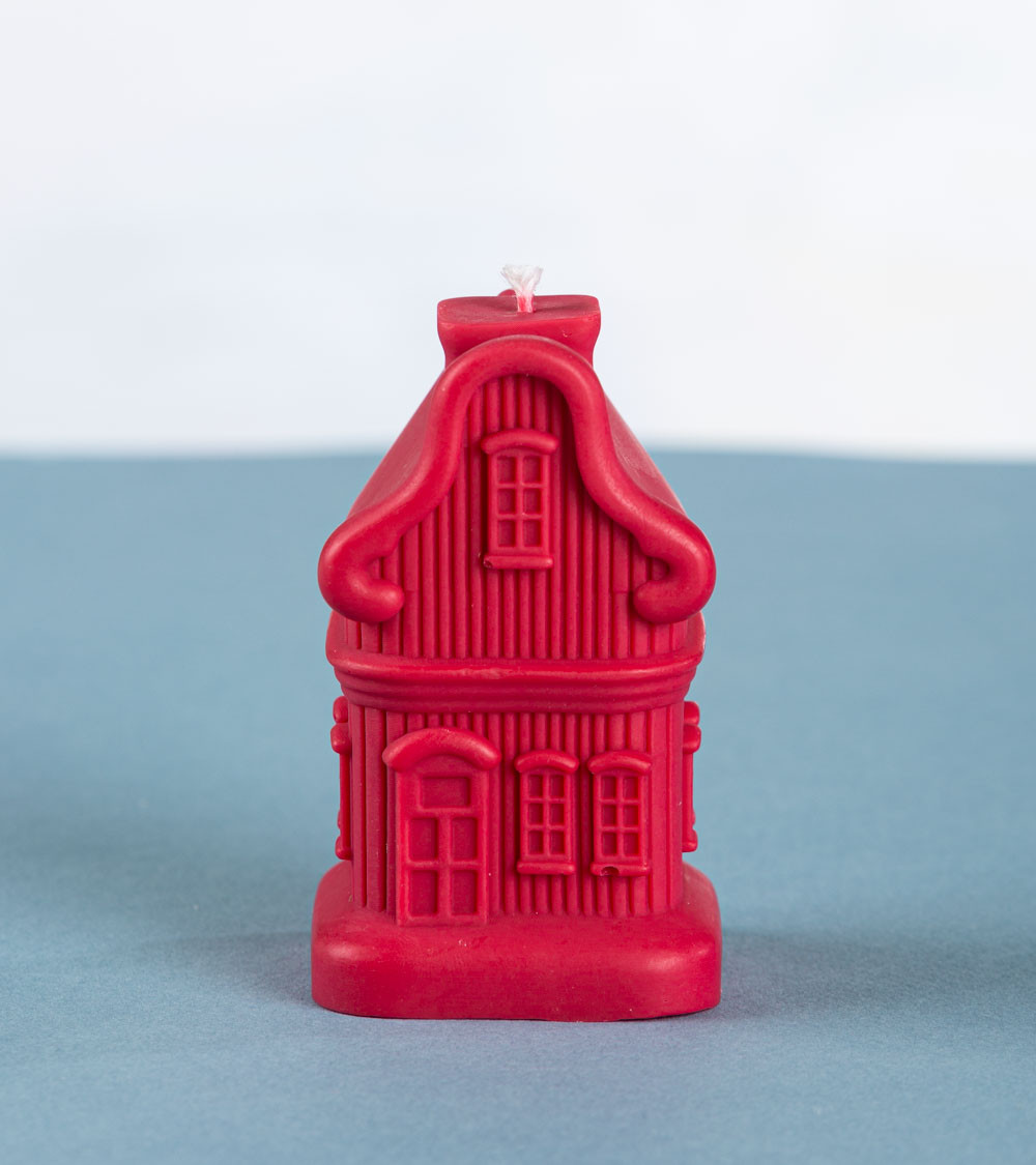 Bougie artisanale "Sweet Dwelling Home" en cire de colza, forme maison de Noël rouge bordeaux – vue de face.