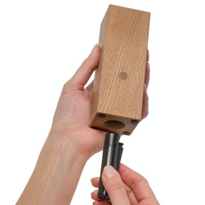 Bougeoir en chêne avec le briquet en main pour utilisation.