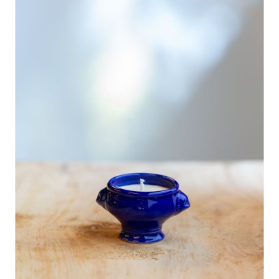 Bougie parfumée dans une cocotte en céramique bleu foncé.