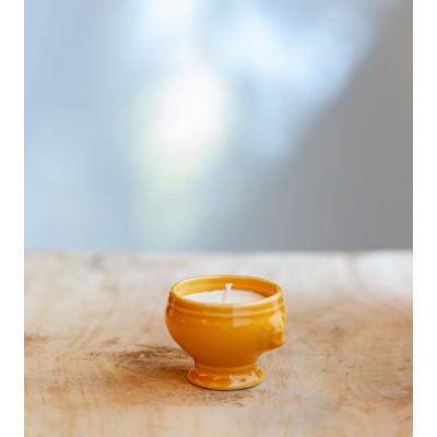 Bougie dans une cocotte jaune, ajoutant une touche colorée et élégante.