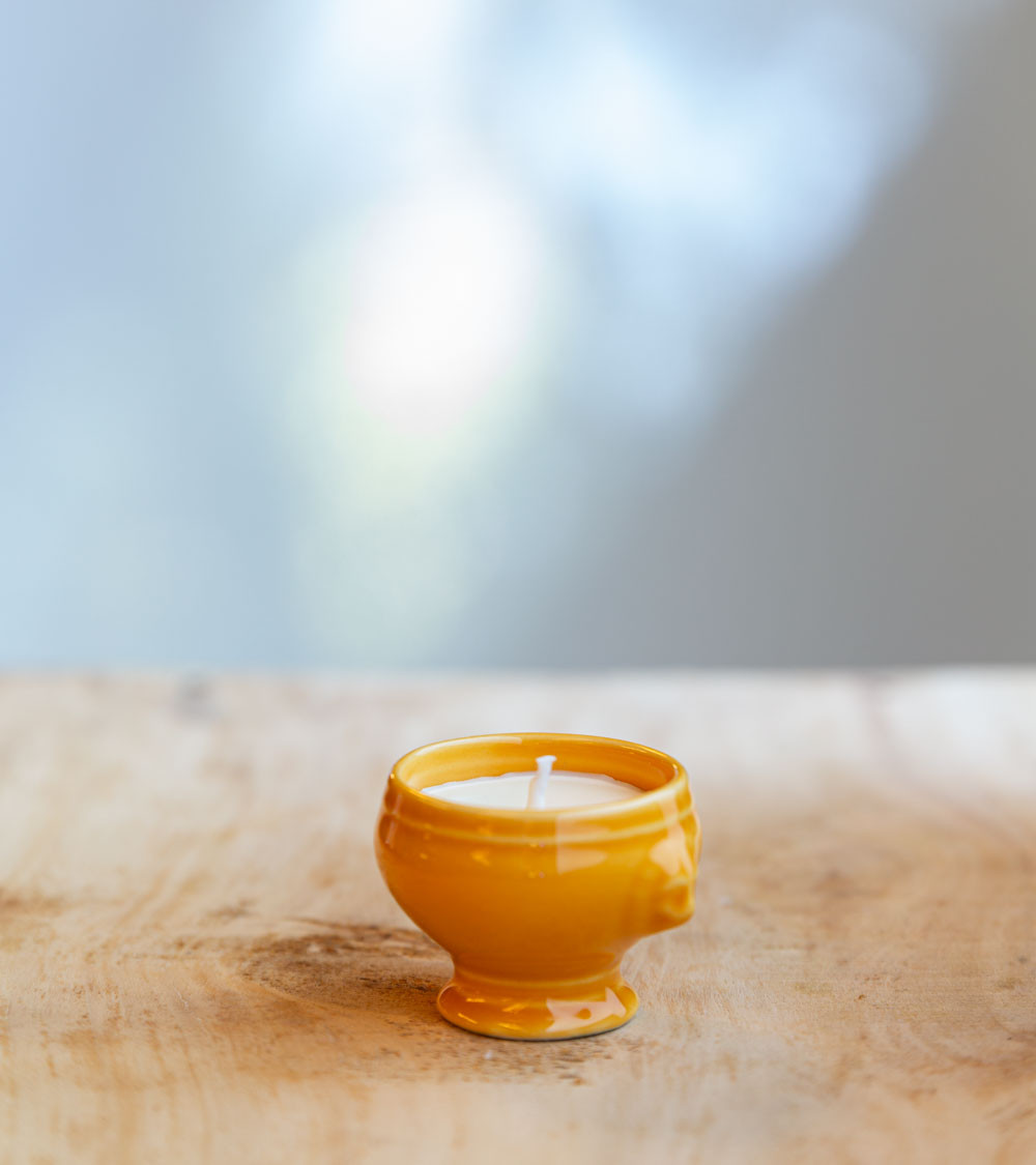 Bougie dans une cocotte jaune, ajoutant une touche colorée et élégante.