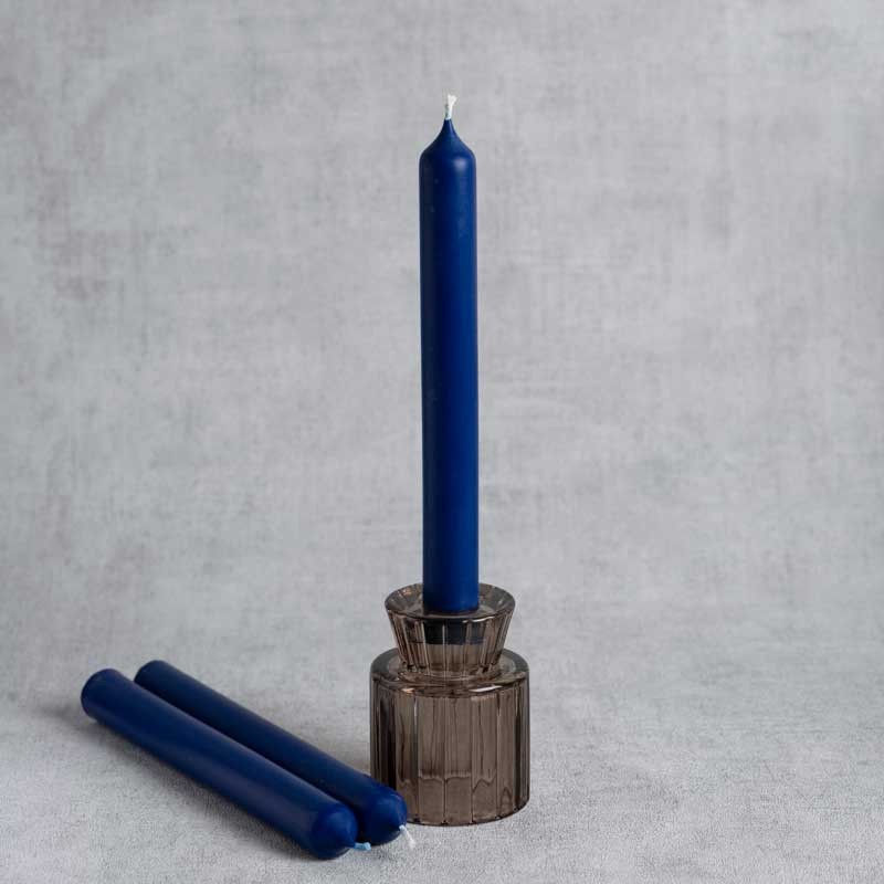 Bougies chandelles artisanales bleu royal en cire de colza, présentées avec un bougeoir en verre fumé
