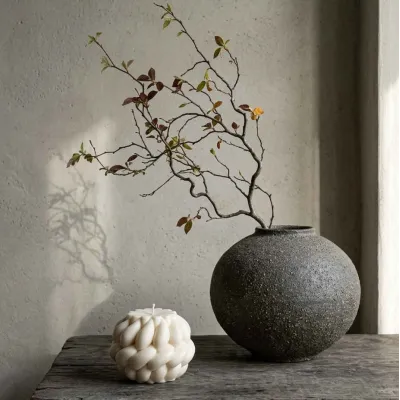 Bougie tressée "Oladie" en cire végétale – mise en scène naturelle avec vase en grès